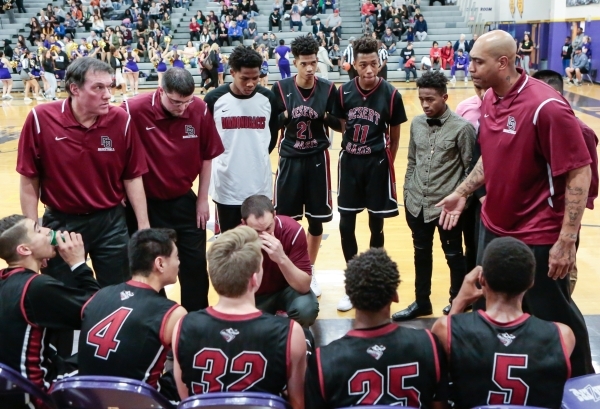 Desert Oasis assistant coach Marcus Fizer, far right, talks with the team during a timeout, ...