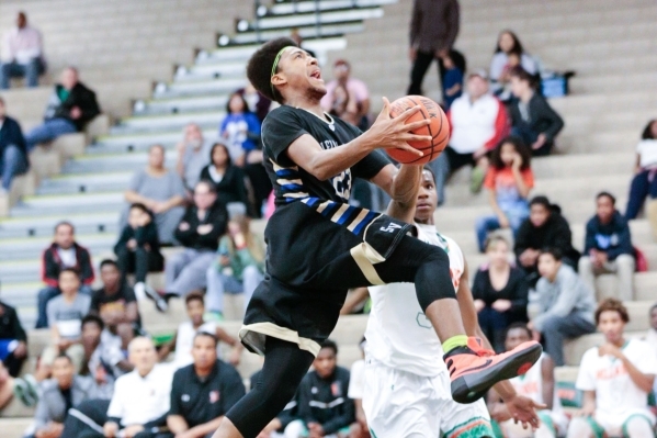 Sierra Vista junior Chris McCoy (23) goes to the basket as Mojave senior Daryl Adams (3) def ...