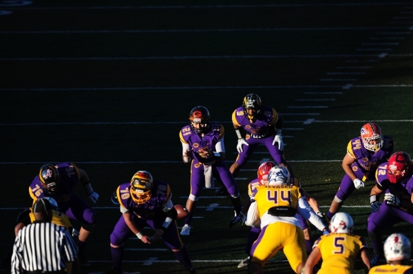Sunset All-Stars quarterback Tanoa Alapati, middle, fields the snap by center Jonathan Galli ...
