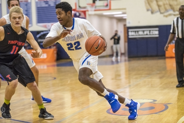 Bishop Gorman guard Christian Popoola Jr. (22) drives to the basket while being defended by ...