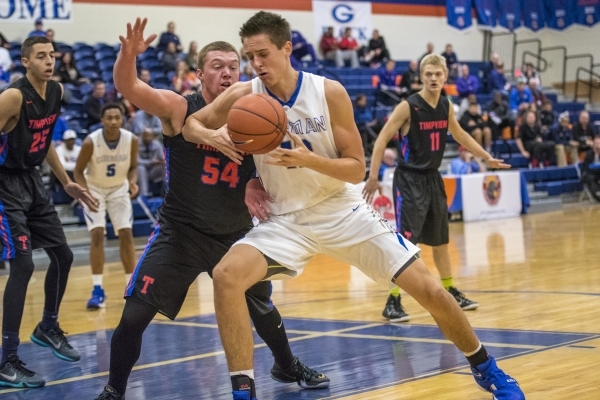 Bishop Gorman center Zach Collins (12) tries to control the ball while being defended by Tim ...