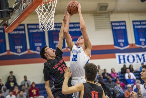 Bishop Gorman center Zach Collins (12) takes the ball to the basket while being defended by ...