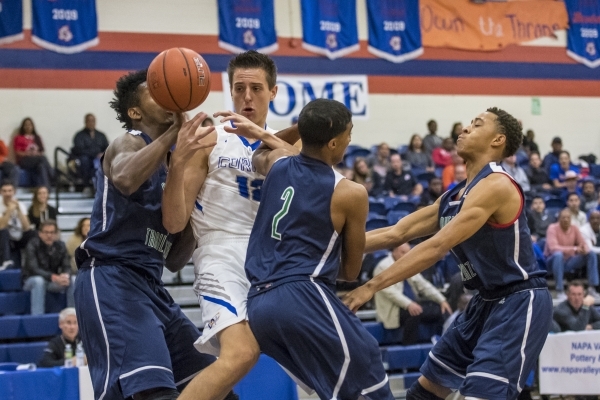 Bishop Gorman center Zach Collins (12) juggles the ball while being defended by Overland, Co ...