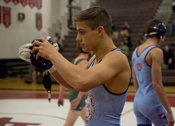 Centennial‘s Nico Antuna puts on his headgear before heading out onto the mat during a ...