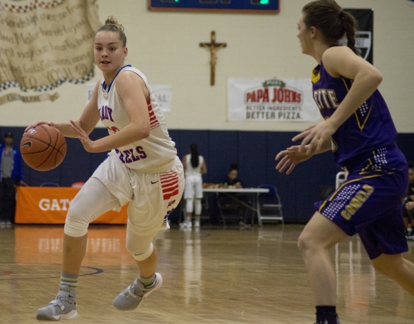 Bishop Gorman‘s Megan Jacobs (23) takes the ball up the court as Nyah Hall (3) of the ...