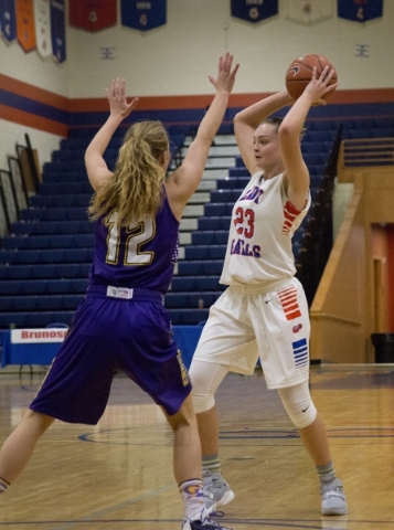 Bishop Gorman‘s Megan Jacobs (23) looks to pass the ball as Kennedy Wilkerson (12) of ...