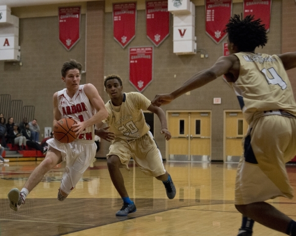 Arbor View‘s Jesse Vogel (11) drives to the basket as Shadow Ridge‘s Isaiah ...