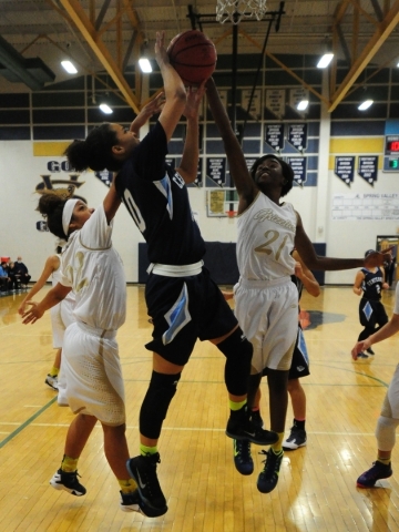 Spring Valley guard Alana Walker (21) swats the ball out of bounds from Centennial guard Jay ...