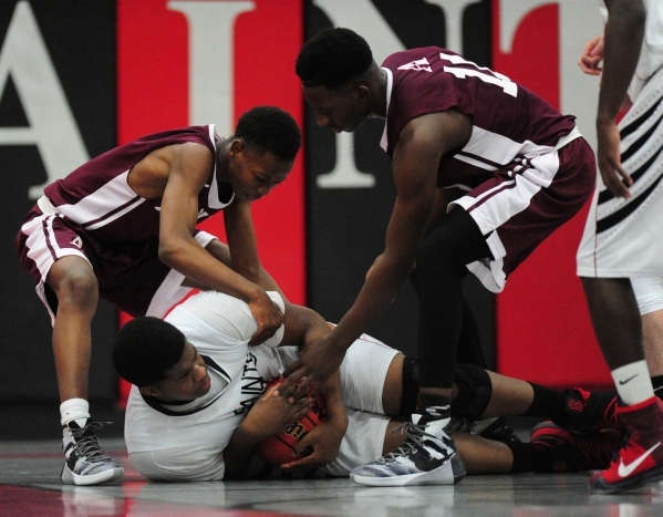 Agassi Prep guard Najeeb Muhammad, left, and forward Jared Holmes (11) fight with Mountain V ...
