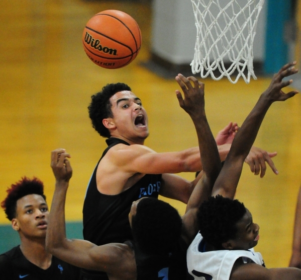 Canyon Springs forward Joseph Haulcy, center, fights Silverado guard Errol Newman, far right ...