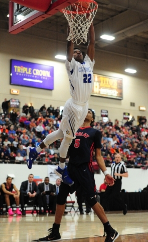 Bishop Gorman guard Christian Popoola (22) dunks in front of Findlay Prep guard P.J. Washing ...