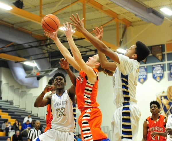 Chaparral guard Ben Kirschbaum, center, collects a rebound in front of Sierra Vista forwards ...