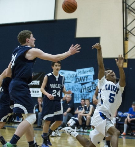 Calvary Chapel‘s Quentin Hank (5) takes a shot at the basket as he goes down in the bo ...