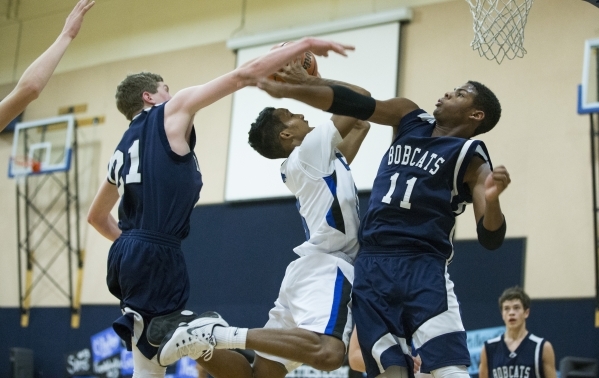 Calvary Chapel‘s Quentin Hank (5) takes a shot to the basket as White Pine‘s Jon ...