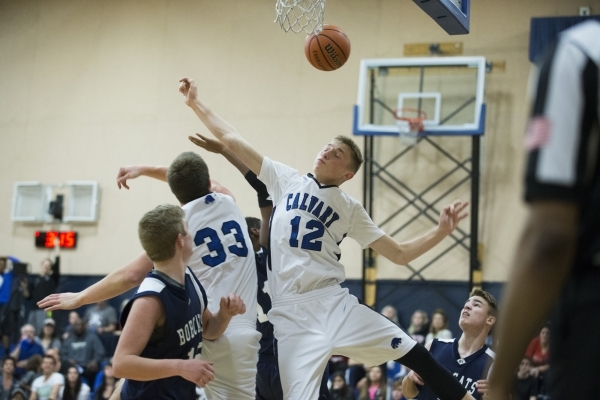 Cavalry Chapel‘s Alec Neider (12) and James Gentile (33) jump for a rebound in the boy ...