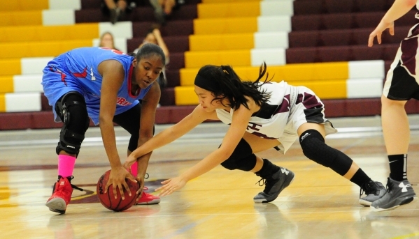 Western guard Capricia Pierce, left, and Faith Lutheran guard Maddie Bocobo fight for a loos ...