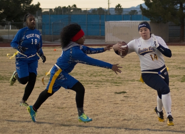 Boulder City quarterback Jeanne Carmell (14) runs by Desert Pines‘ Brenda Lopez (5) d ...