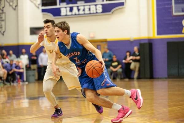 Bishop Gorman senior Byron Frohnen (3) moves the ball down the court while being followed by ...