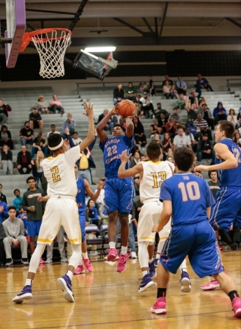 Bishop Gorman junior Christian Popoola (22) shoots for a basket being defended by Durango se ...