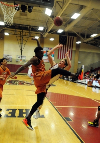 Desert Oasis forward Jacob Heese, background, and Legacy guard Zach Collins are upended afte ...