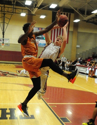 Desert Oasis forward Jacob Heese, background, and Legacy guard Zach Collins are upended afte ...