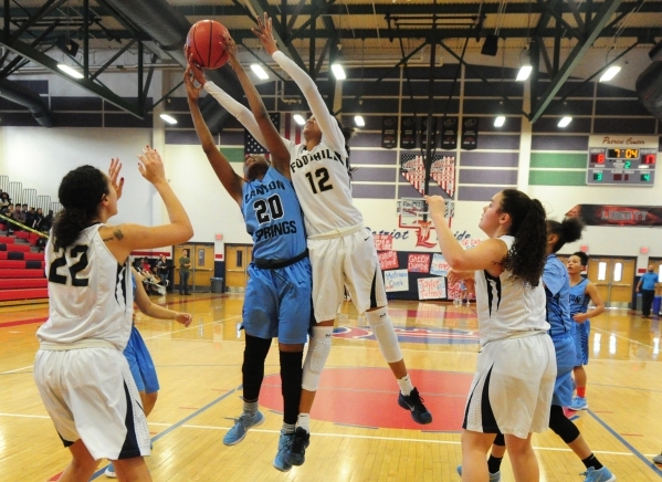 Foothill guard Rae Burrell (12) and Canyon Springs forward Alexia Thrower (20) fight for a r ...