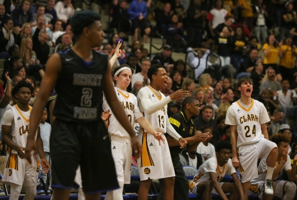 The Clark High School bench celebrates a three point shot during the I-A Southern boys baske ...