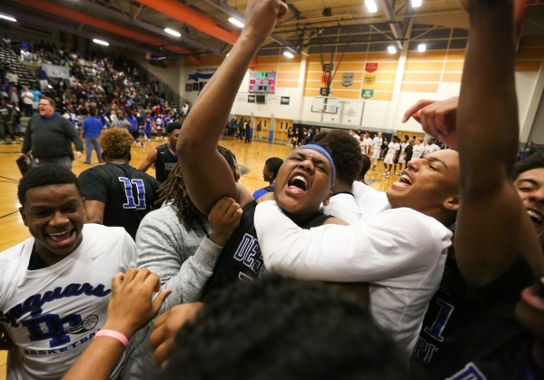 Desert Pines High School jr. Jalen Graves (12), center, is mobbed by teammates after beating ...