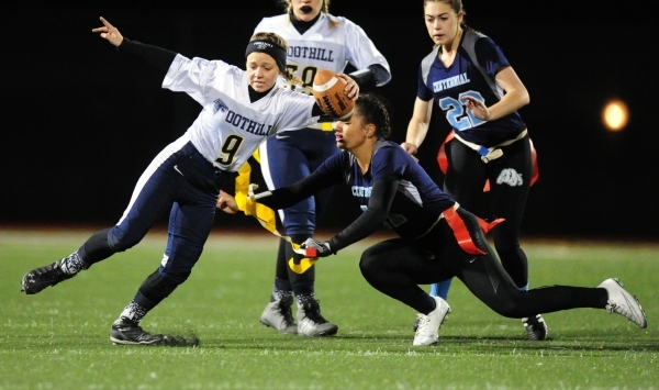 Centennial safety Kayla Kipp-Nobles, right, pulls the flag off of Foothill quarterback Jadyn ...