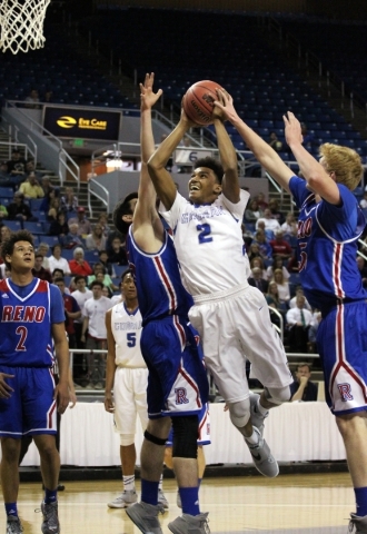 Bishop Gorman‘s Jamal Bey shoots past Reno defenders Michael Heydon, center, and David ...