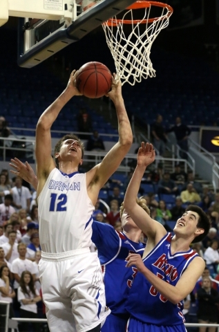 Bishop Gorman‘s Zach Collins shoots over Reno defenders David Kyle, center, and Michae ...