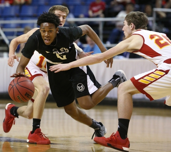 Word of Life‘s Trent McCall drives through Whittell defenders Palmer Chaplin, left, an ...