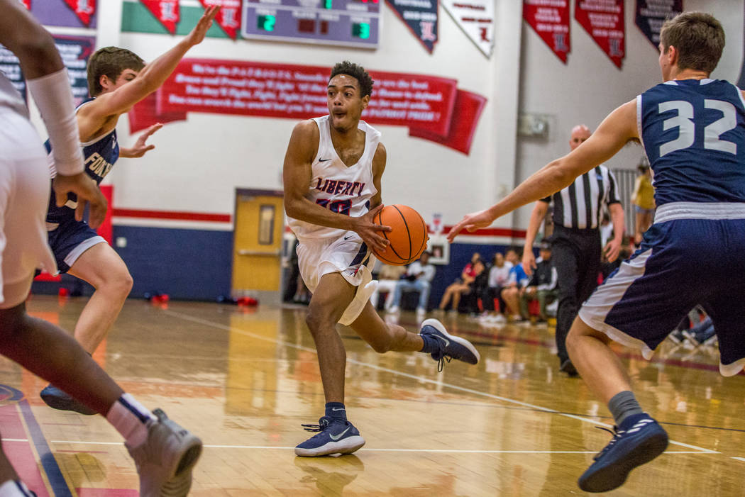 Liberty’s Jordan Holt (10) looks for a shot while Foothill’s Aucyon Mathews (3), ...