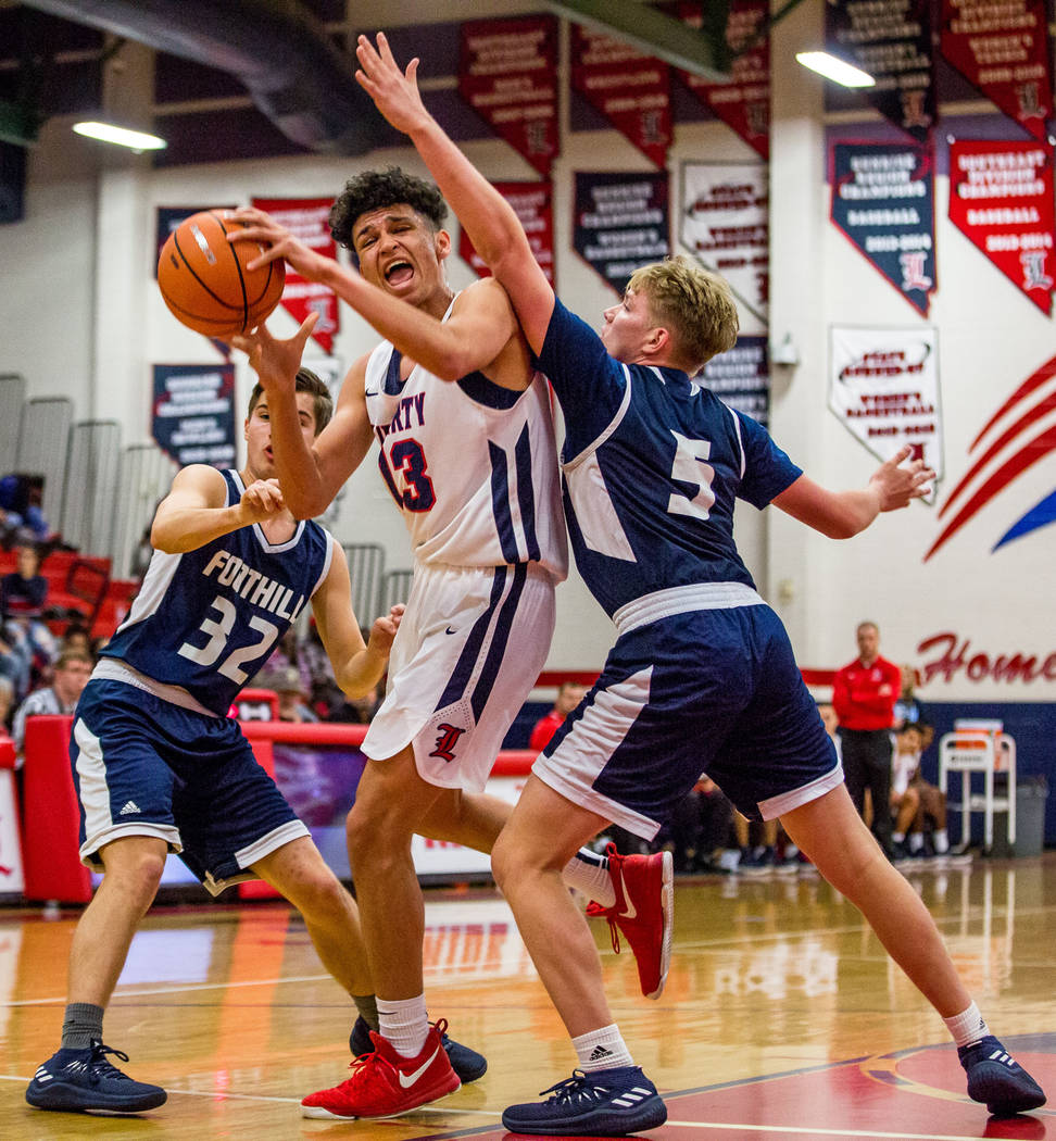 Liberty’s Terrance Marigney (13) tries to get around Foothill defenders Dylan Hushaw ( ...