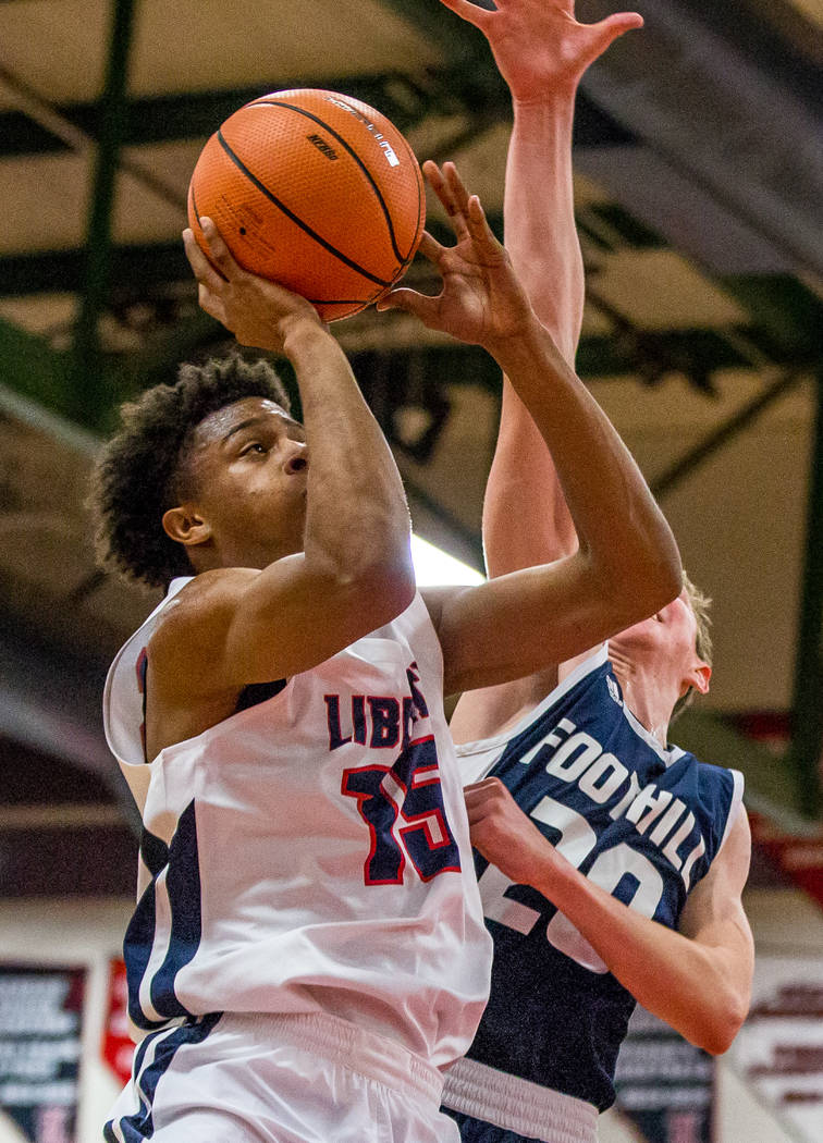 Liberty’s Cameron Burist (15) goes up for a shot while Foothill’s Caleb Stearman ...