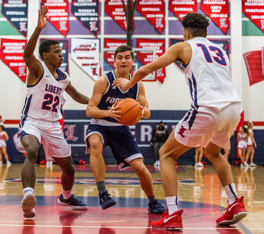 Foothill’s Dylan Hushaw (32) looks for a shot while Liberty defenders Jordan Wafer (22 ...