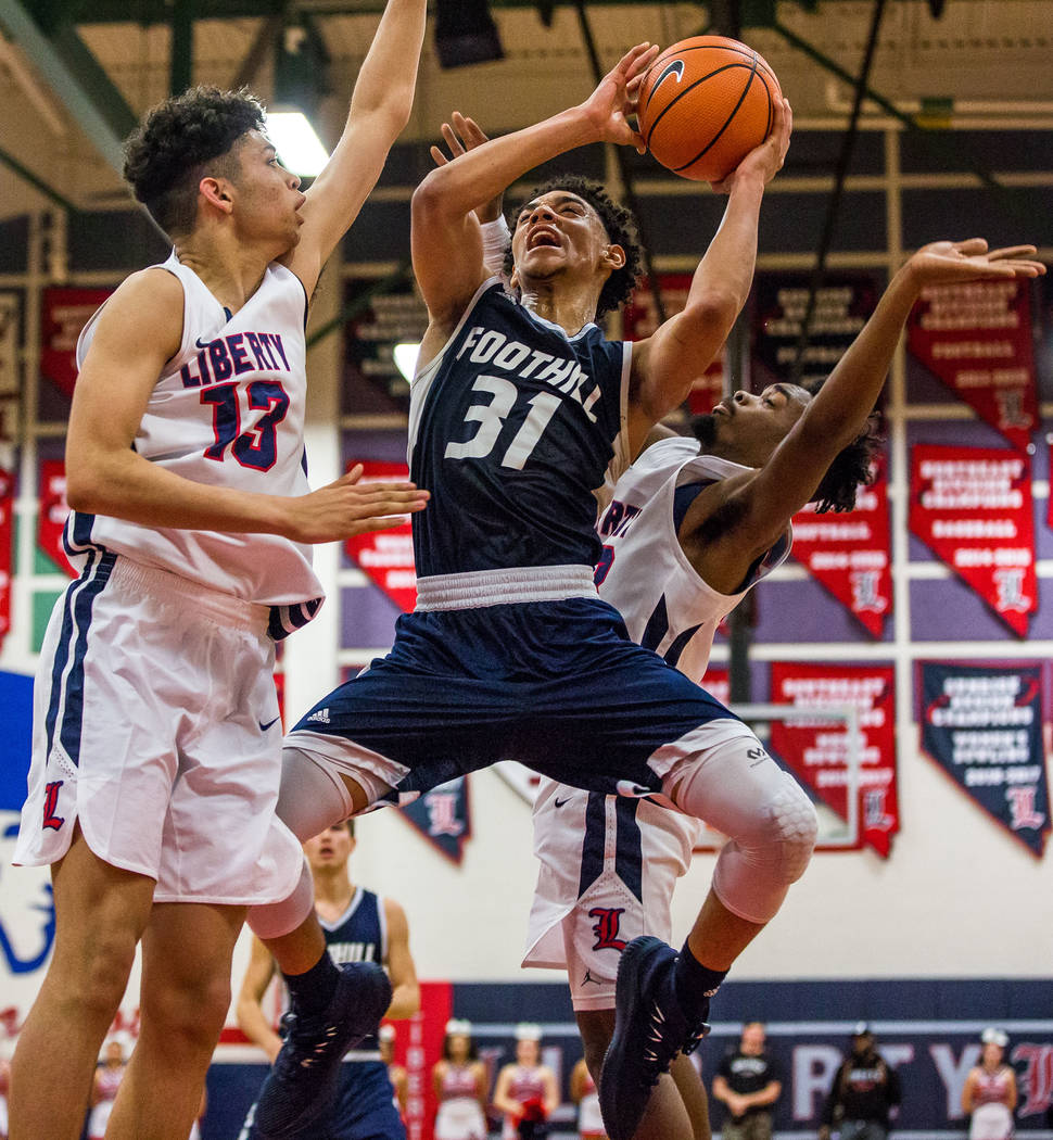 Foothill’s Marvin Coleman (31) goes up for a shot while Liberty’s Terrance Marig ...
