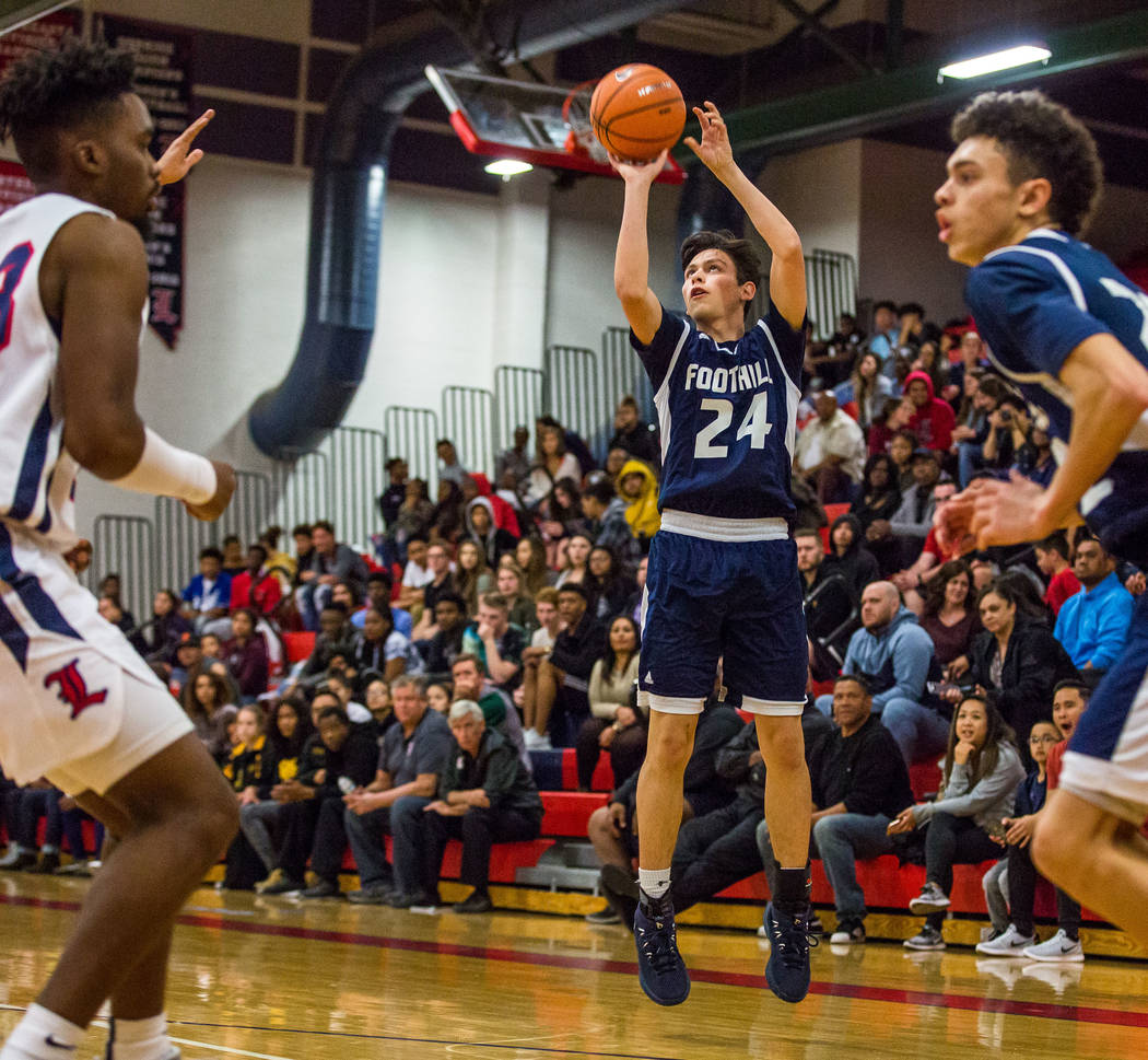 Foothill’s Anthony Martin (24) looks for a 3-pointer while Jace Roquemore (22), right, ...