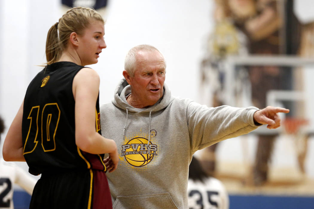 Pahrump Valley’s coach Robert Hopkins talks to Sam Runnion (10) during a basketball ga ...