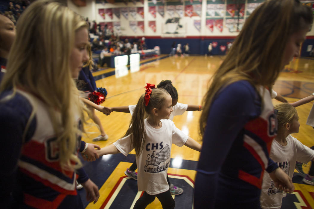 Coronado High School cheerleaders lead young cheerleaders-in-training to perform during half ...