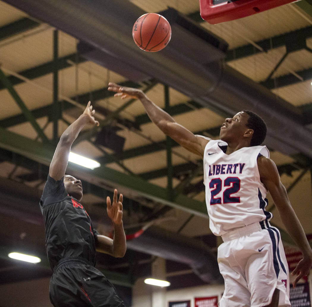 Las Vegas’ KJ Johnson (3) throws toward the hoop while Liberty’s Jordan Wafer (2 ...