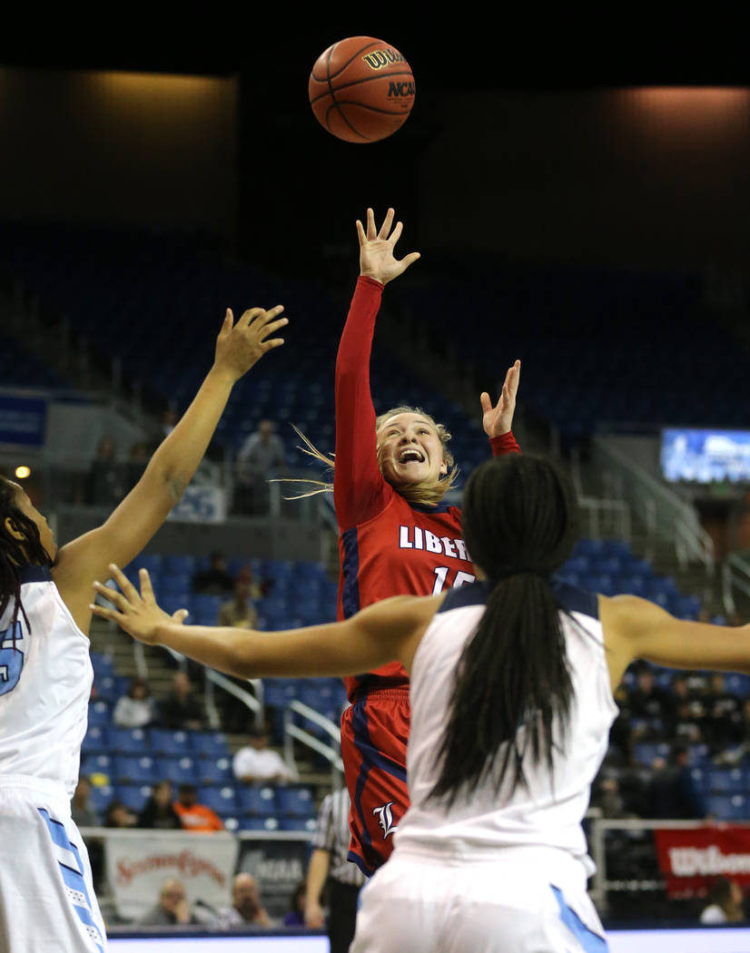 Liberty’s London Pavlica shoots past Centennial defenders during the NIAA state basket ...