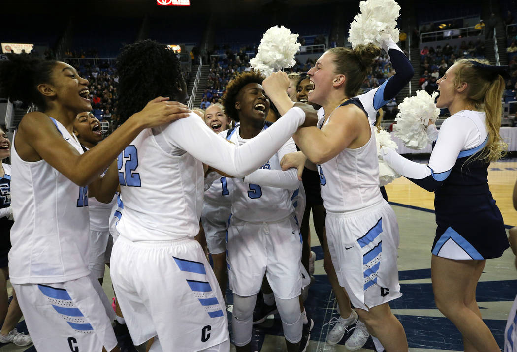 The Centennial Bulldogs celebrate a 74-65 overtime win over Liberty for the NIAA state baske ...