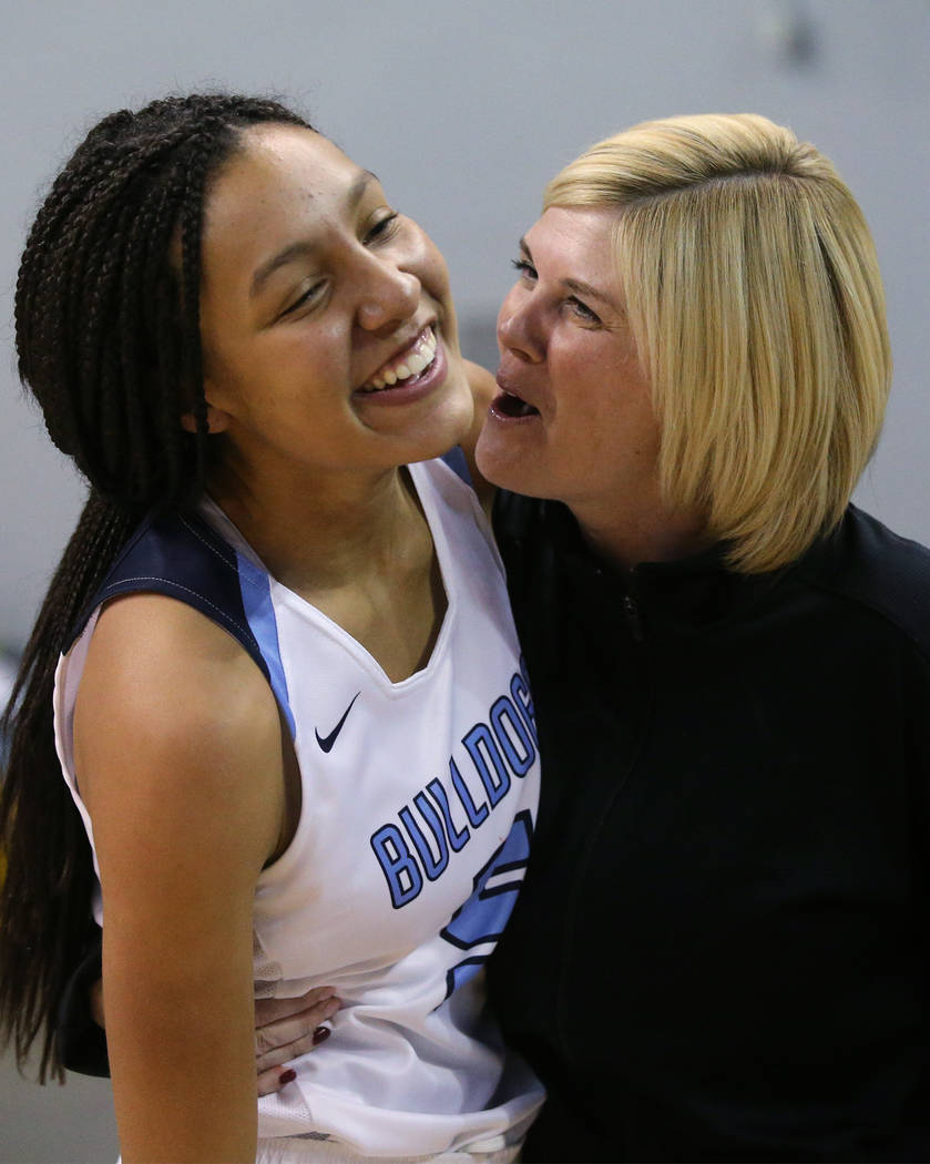 Centennial’s Jade Thomas celebrates with an assistant coach after her shot at the buzz ...