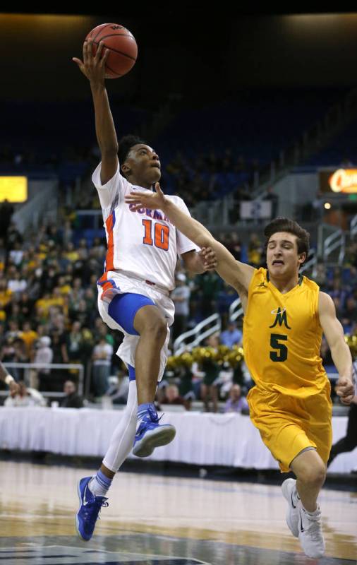 Bishop Gorman’s Zaon Collins shoots over Bishop Manogue defender Mateo Reviglio durin ...