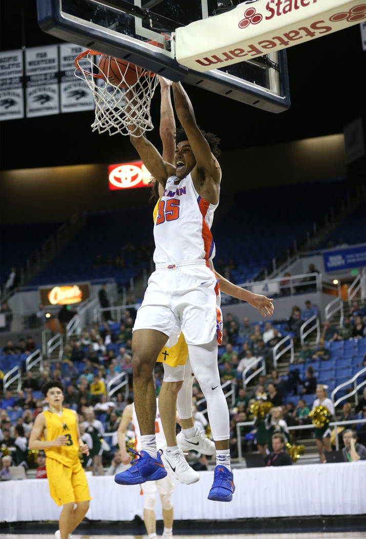Bishop Gorman’s Jamal Bey dunks against a Bishop Manogue defender during the 4A NIAA s ...