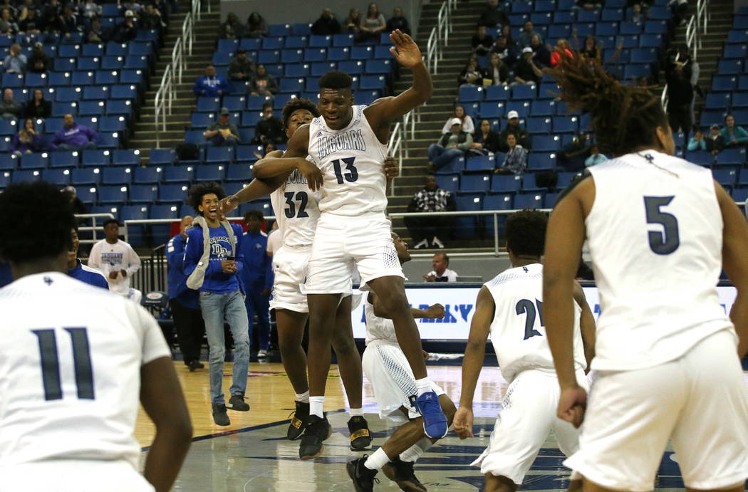 The Desert Pines team celebrates after defeating Cheyenne 48-44 in overtime for the NIAA 3A ...