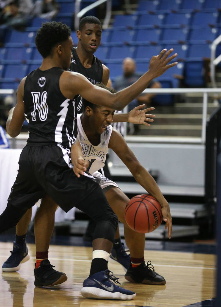 Cheyenne’s Jermaine McCormick, left, and Hahsonie Laushaul guard against Desert Pines& ...