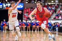 Findlay Prep’s Jack Schwietz (12) drives toward the hoop while Bishop Gorman’s N ...