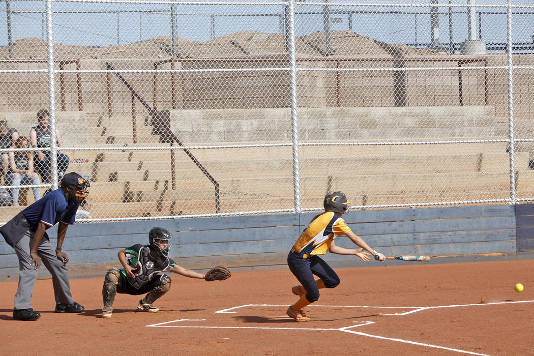 Marleena Mills prepares to dash for first after hitting the ball at a softball game against ...